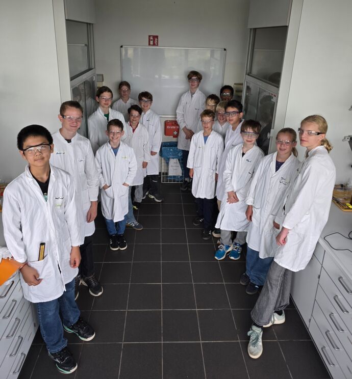 Die Juniorforscher*innen der IJSO in Laborkitteln bei den JuniorForscherTagen 2026 auf dem Gutenberg-Campus in Mainz